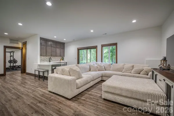 a living room with furniture a flat screen tv and a large window