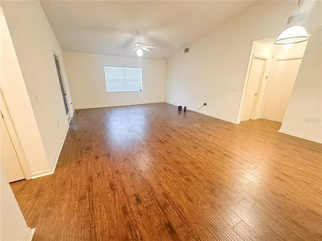 a view of empty room with wooden floor