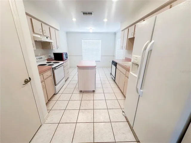a kitchen with a sink a stove a refrigerator and cabinets