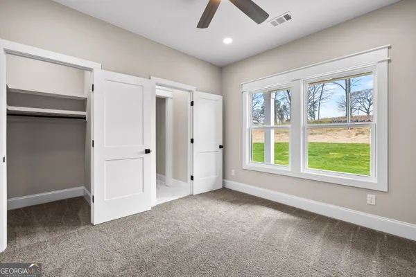 a view of an empty room with wooden floor fireplace and a window