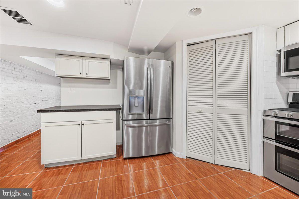 30 R Street Northeast, Unit B Washington, DC 20002 - Photo 12 of 21 a kitchen with white cabinets and stainless steel appliances