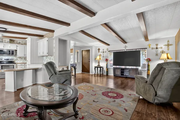a living room with furniture a flat screen tv and kitchen view