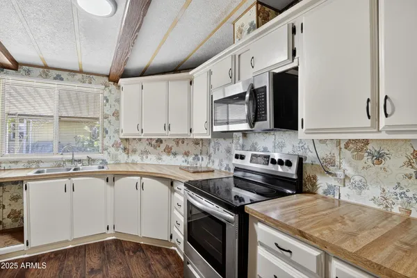 a kitchen with stainless steel appliances granite countertop a sink a stove a microwave and cabinets