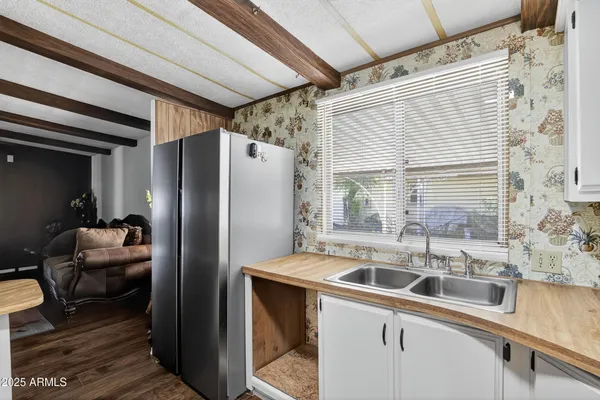 a kitchen with stainless steel appliances granite countertop a sink a refrigerator and a granite counter tops with a window