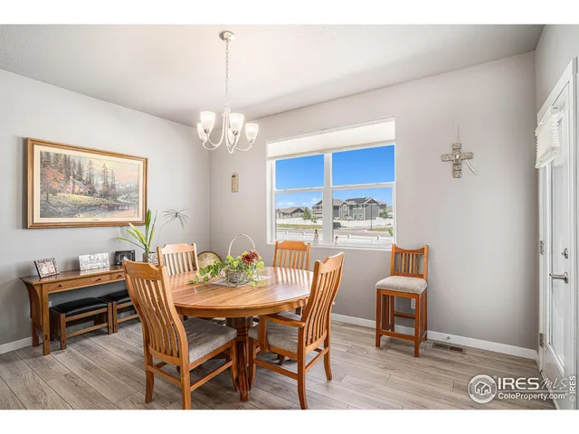 a dining room with furniture a chandelier and wooden floor