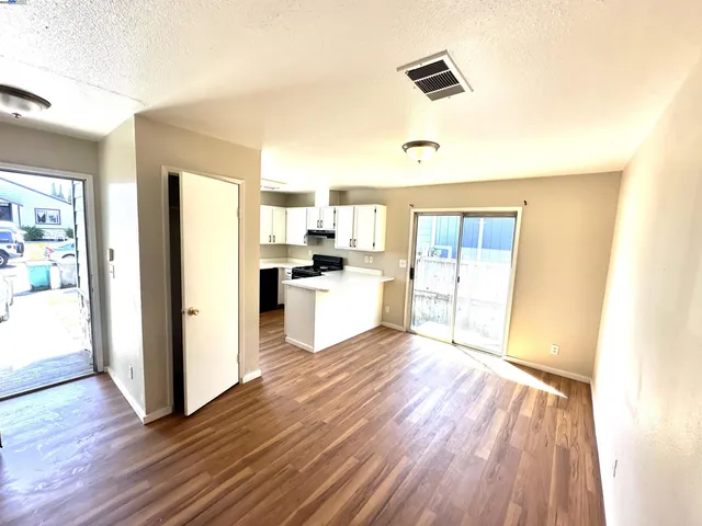 a view of a kitchen with wooden floor and electronic appliances