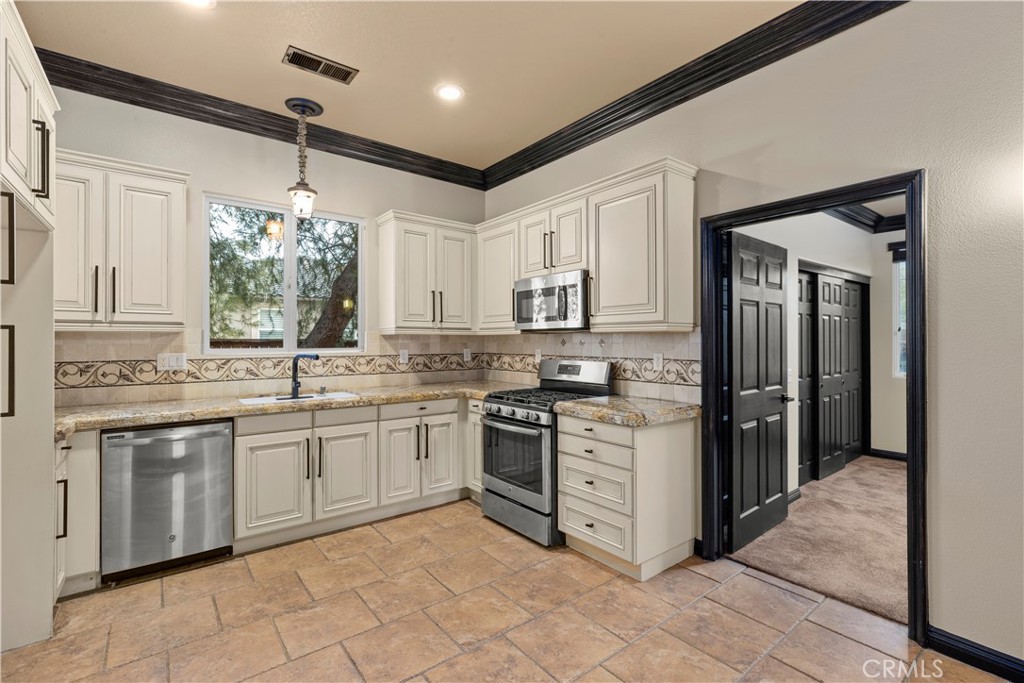 18301 Lakepointe Drive Riverside, CA 92503 - Photo 45 of 67 a kitchen with stainless steel appliances granite countertop a stove sink and cabinets