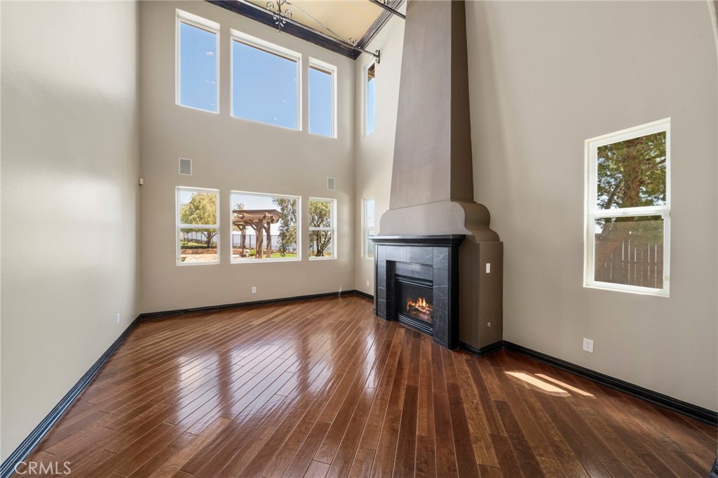 18301 Lakepointe Drive Riverside, CA 92503 - Photo 6 of 67 an empty room with wooden floor fireplace and windows