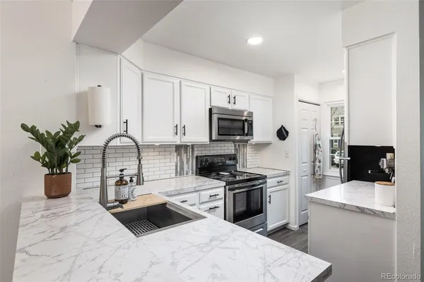 a kitchen with a sink appliances and cabinets