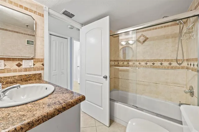 a bathroom with a granite countertop tub sink and mirror