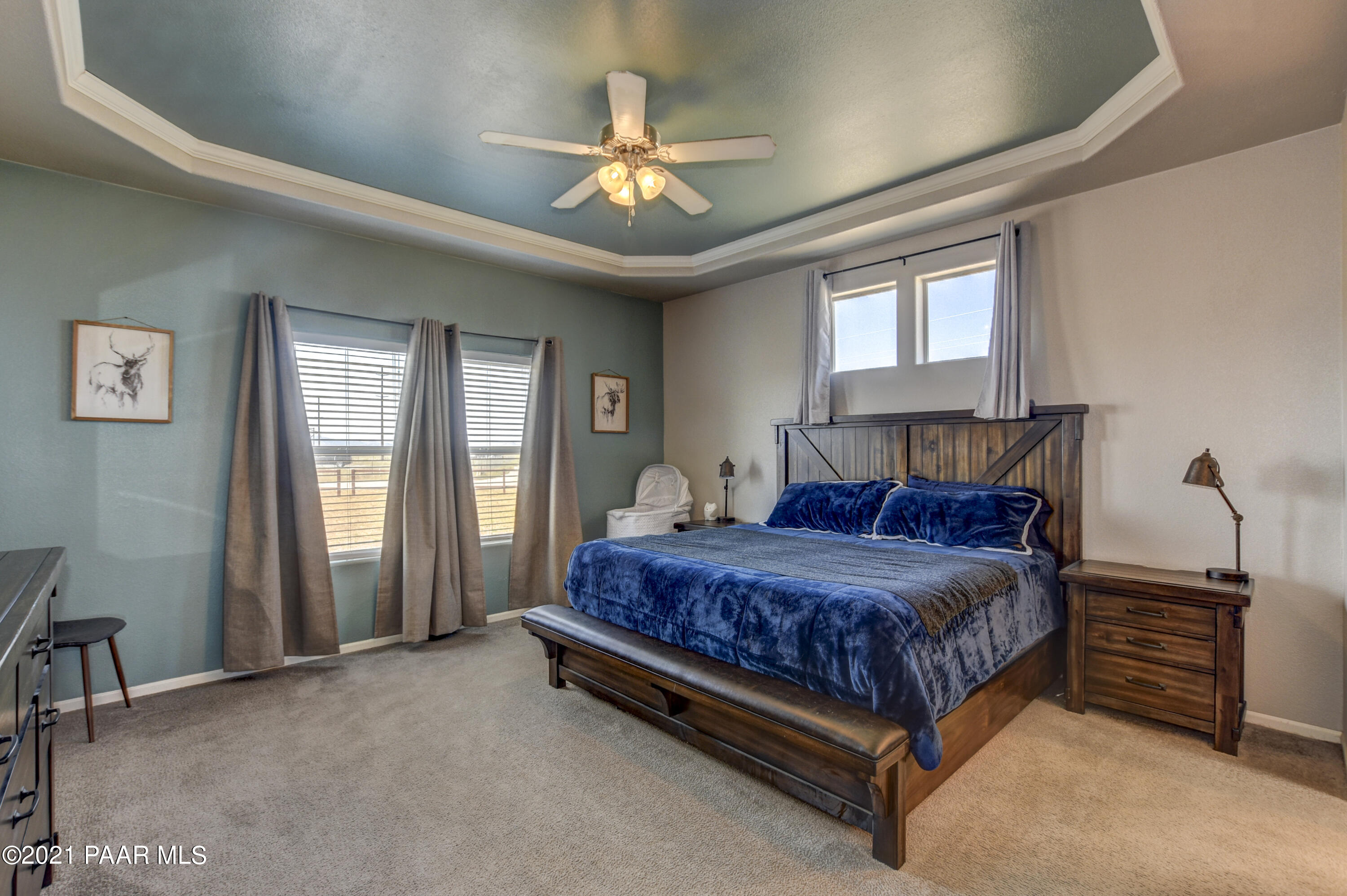 12301 North Poquito Valley Road Prescott Valley, AZ 86315 - Photo 9 of 31 a spacious bedroom with a bed a chandelier and a window