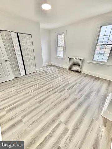 a view of a bedroom with wooden floor and windows