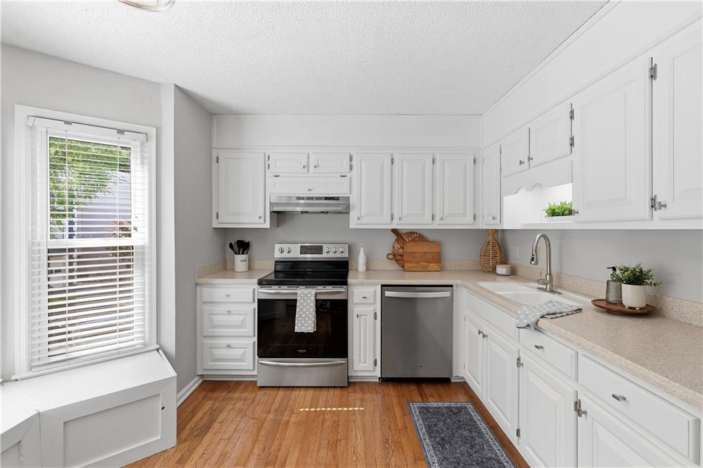 3800 Meeting Street Northwest Duluth, GA 30096 - Photo 14 of 46 a kitchen with stainless steel appliances granite countertop a stove a sink and white cabinets