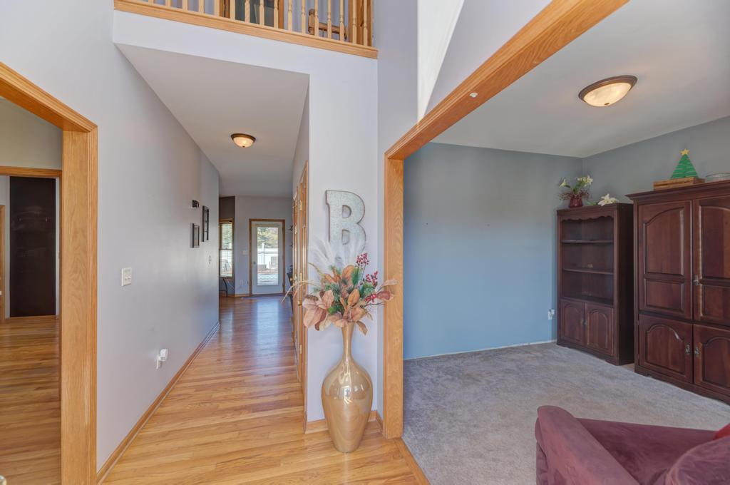 1648 Periwinkle Drive Morris, IL 60450 - Photo 3 of 40 a view of a hallway to a livingroom with wooden floor and furniture