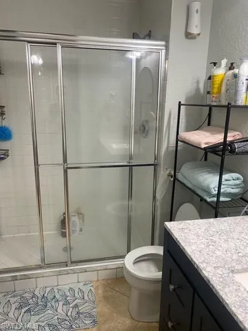 a bathroom with a granite countertop sink toilet and shower