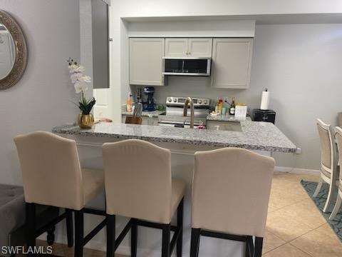 4650 St Croix Lane, Unit 726 Naples, FL 34109 - Photo 2 of 14 a kitchen with stainless steel appliances granite countertop a sink a stove a microwave a refrigerator and cabinets