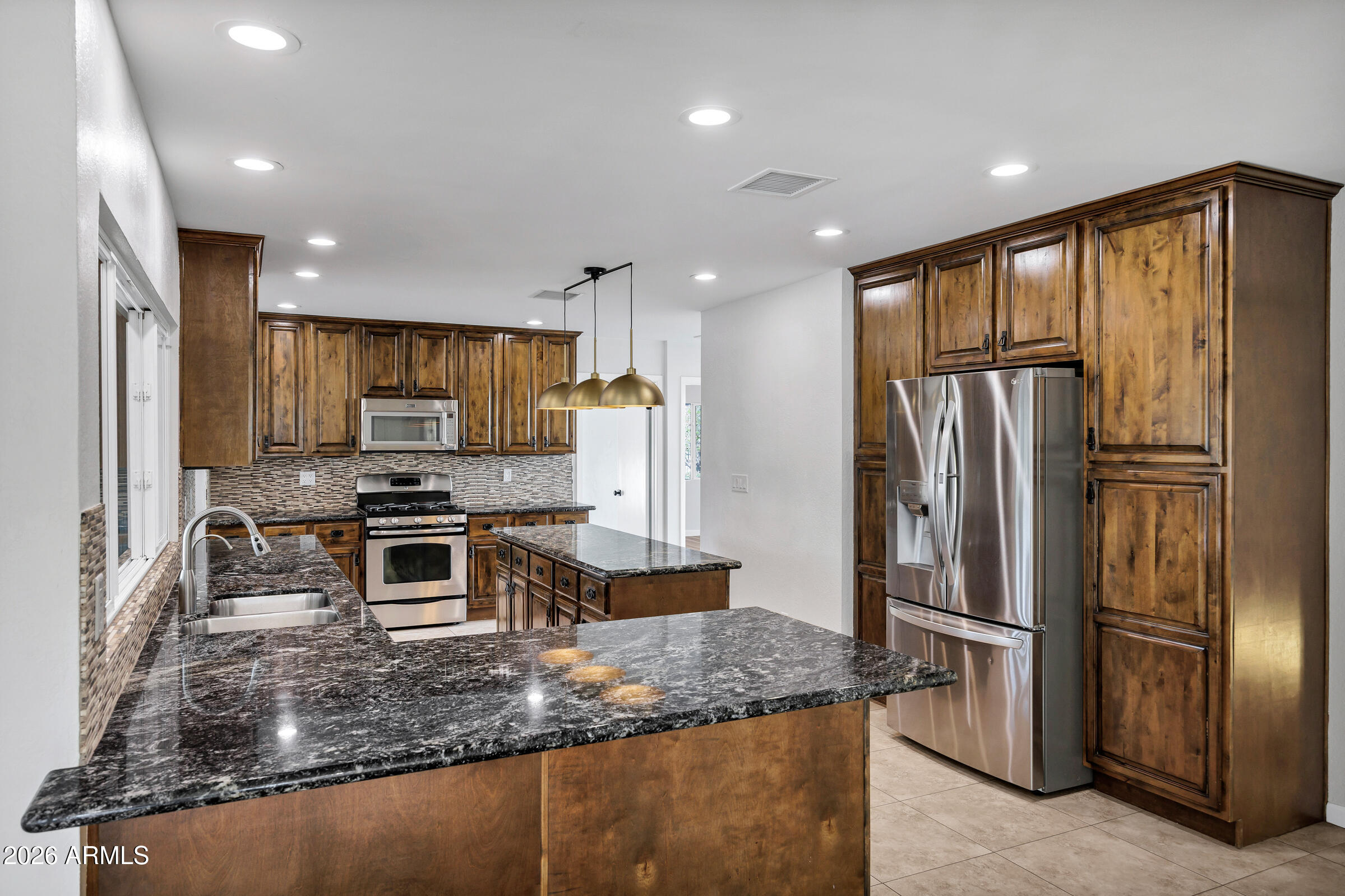 11202 North 42nd Place Phoenix, AZ 85028 - Photo 13 of 55 a kitchen with stainless steel appliances granite countertop a refrigerator a stove a sink and a granite counter tops