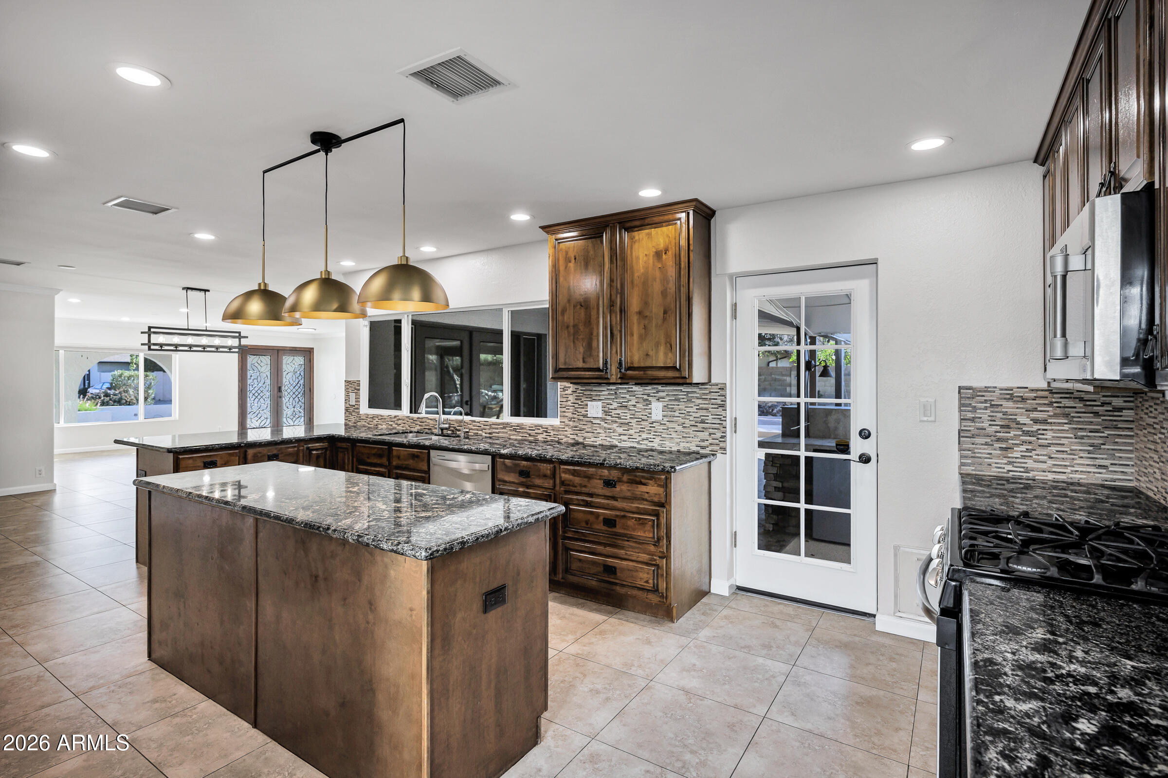 11202 North 42nd Place Phoenix, AZ 85028 - Photo 15 of 55 a kitchen with stainless steel appliances granite countertop a stove a sink and a refrigerator
