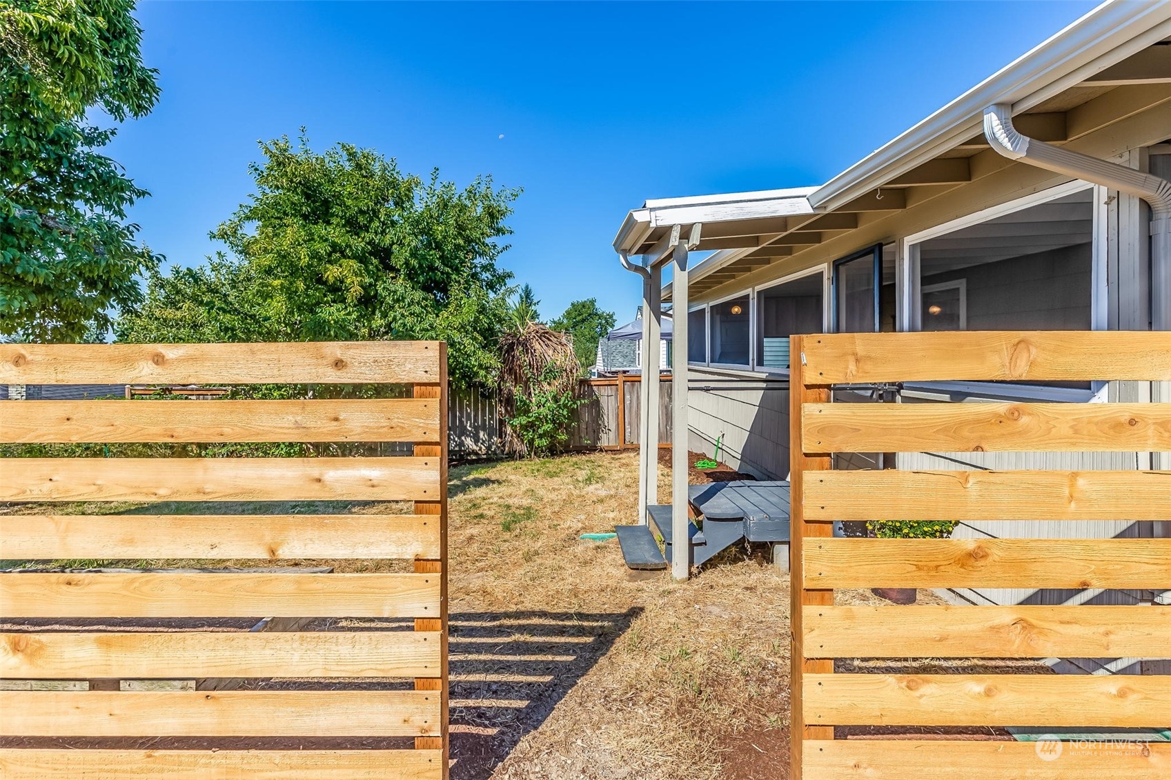 3525 Southwest Webster Street Seattle, WA 98126 - Photo 31 of 37 a view of a house with a large tree and wooden fence