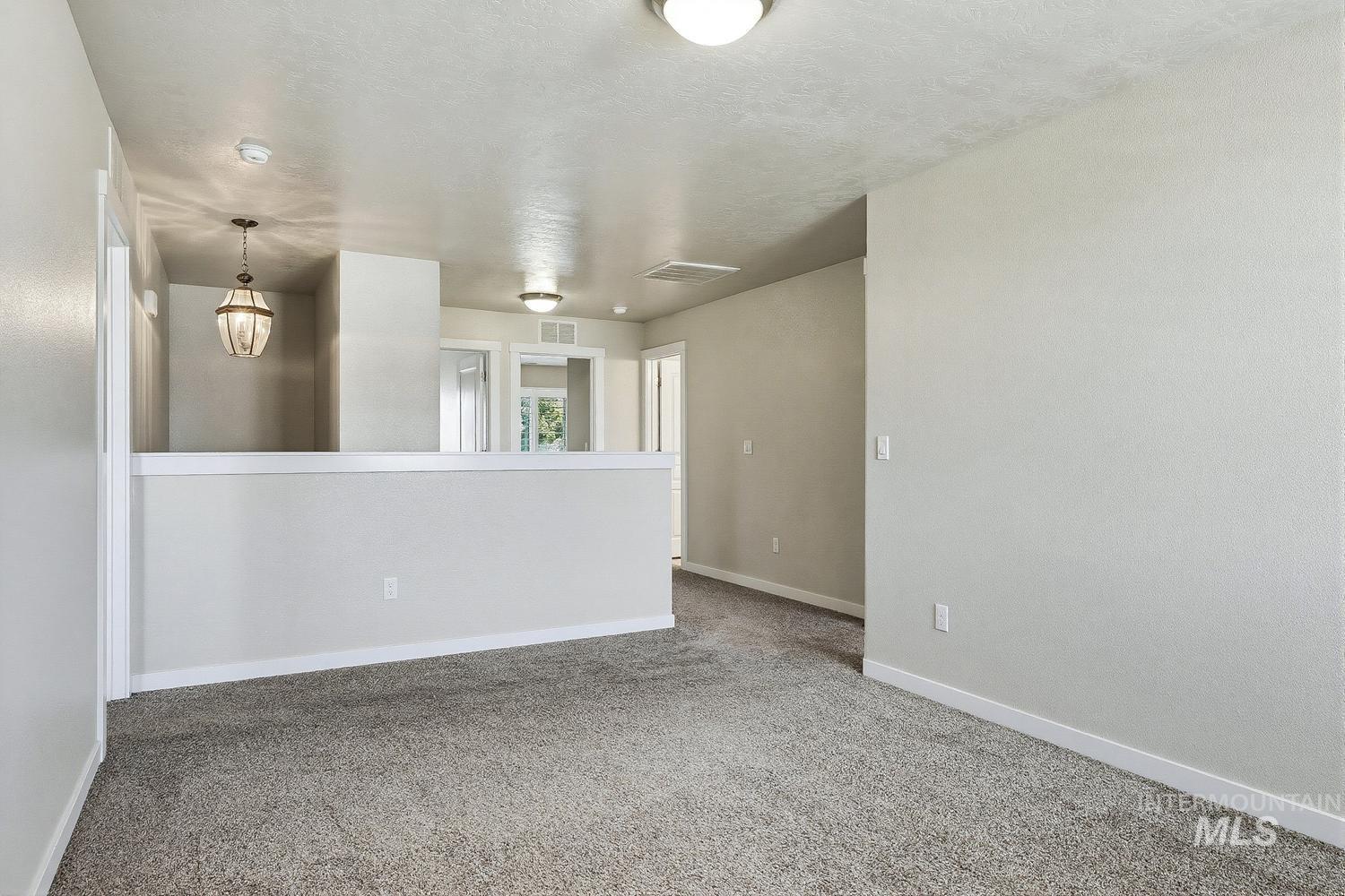 846 North Hidden View Way Star, ID 83669 - Photo 30 of 49 Carpeted upper-level landing featuring a half-wall partition, recessed lighting, and a decorative pendant light fixture