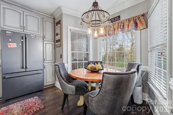 a dining room with furniture a chandelier and wooden floor