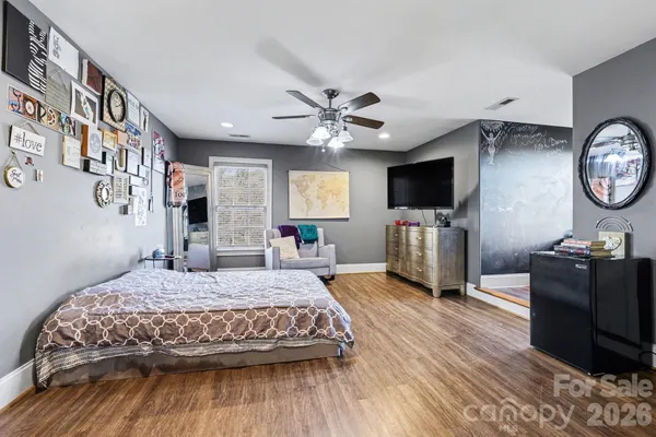 a bedroom with a bed and a flat tv screen on dresser