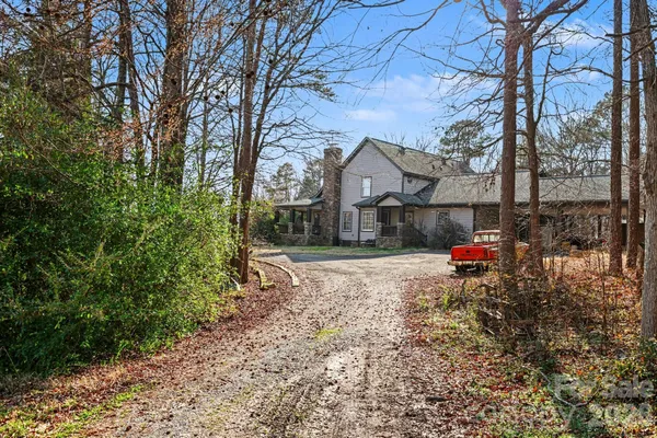 a view of a house with a yard and a tree
