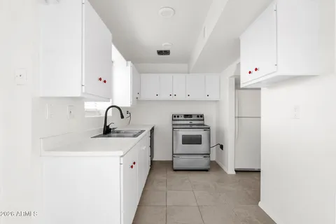a kitchen with white cabinets and white appliances