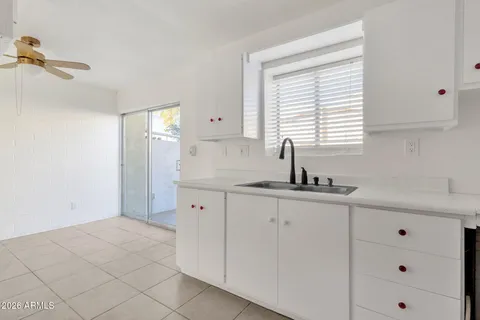 a kitchen with granite countertop a sink a stove and cabinets