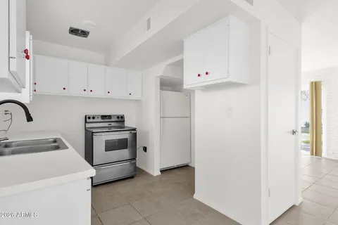 a kitchen with white cabinets and white appliances
