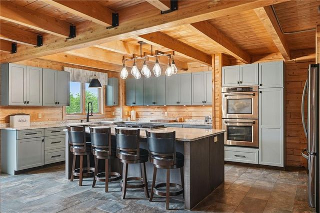 a kitchen with a sink a stove and chairs