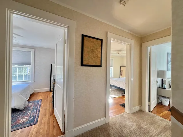 a view of a hallway with bathroom and wooden floor