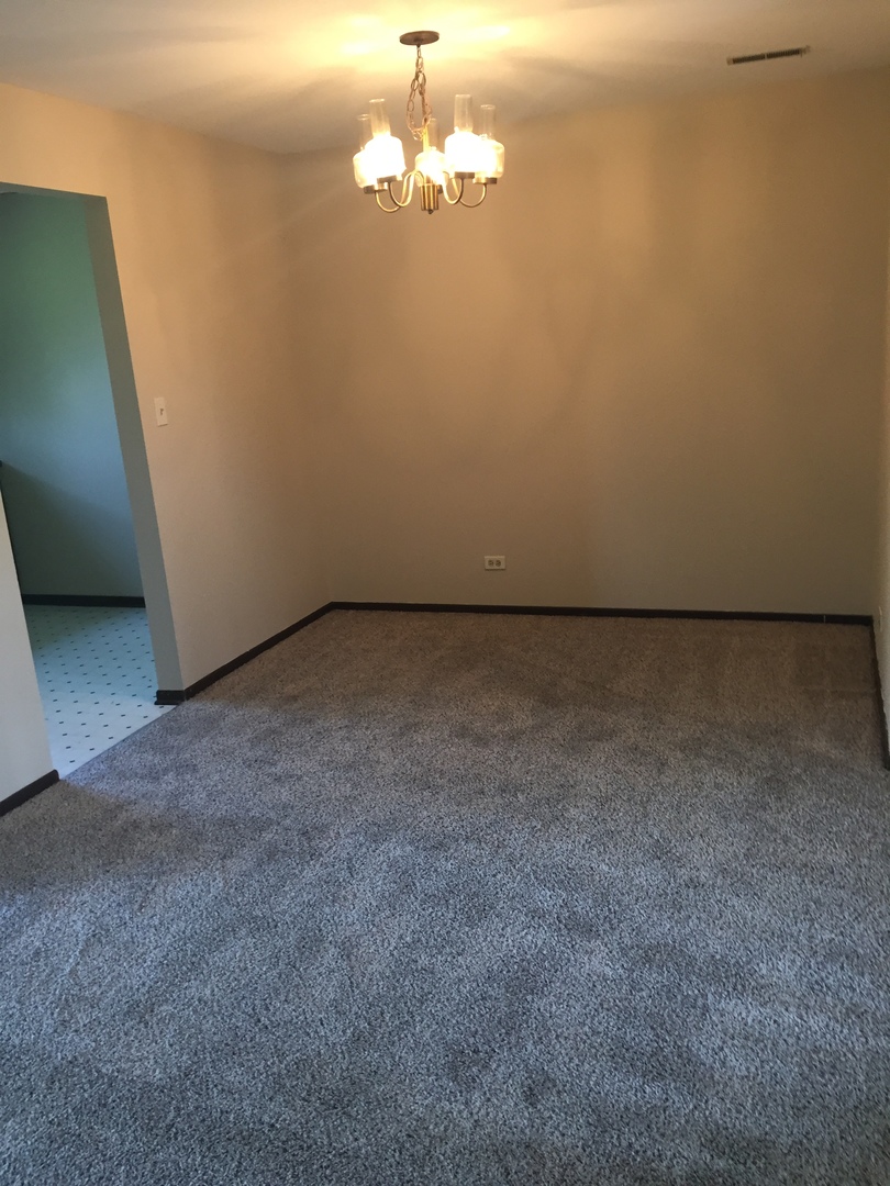855 Johnstown Lane, Unit B Wheaton, IL 60189 - Photo 3 of 10 a view of an empty room with a chandelier fan