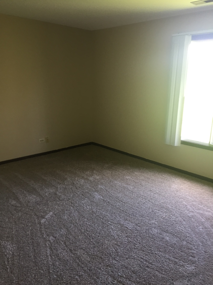 855 Johnstown Lane, Unit B Wheaton, IL 60189 - Photo 7 of 10 a view of an empty room with a window