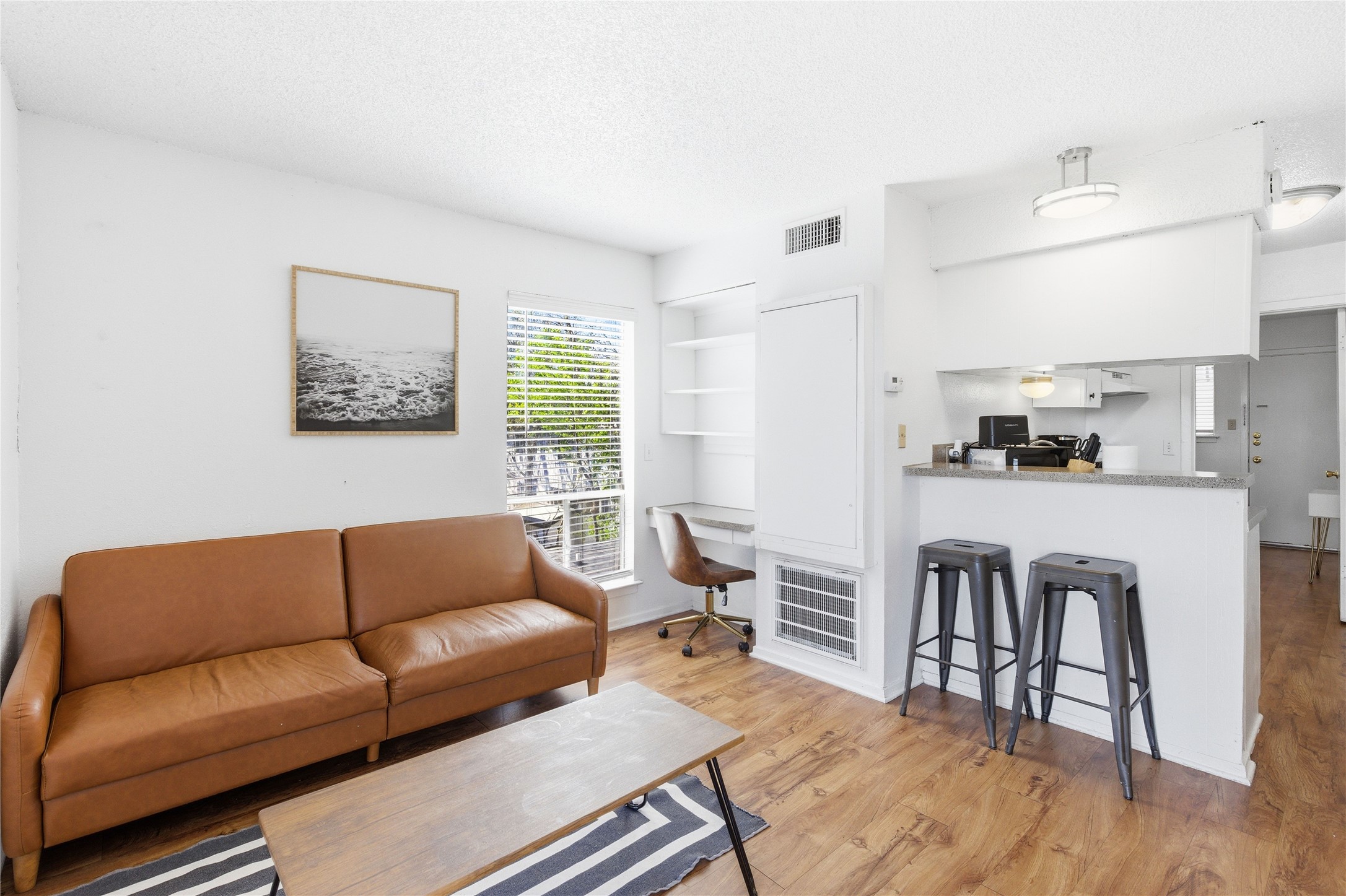a living room with furniture and a wooden floor