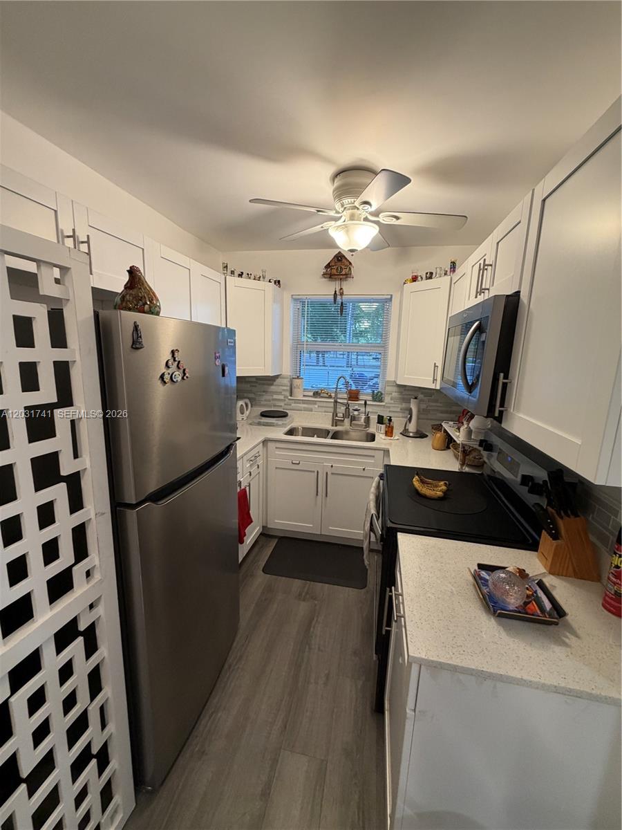 3500 Harrison Street, Unit 4 Hollywood, FL 33021 - Photo 5 of 10 a kitchen with a refrigerator a sink and cabinets