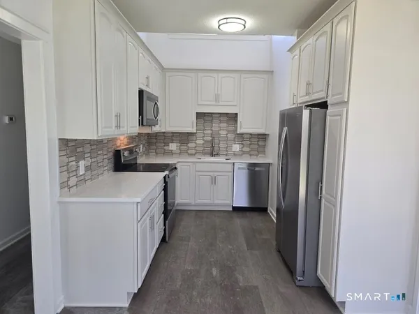 a kitchen with stainless steel appliances a refrigerator sink and cabinets