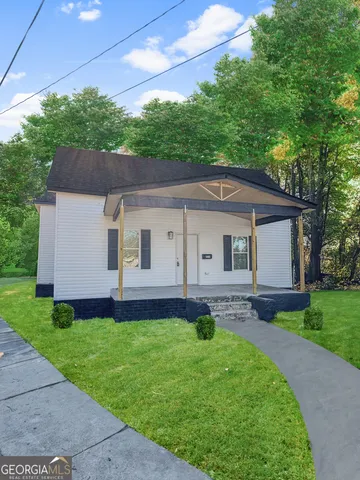 a front view of a house with a garden and yard