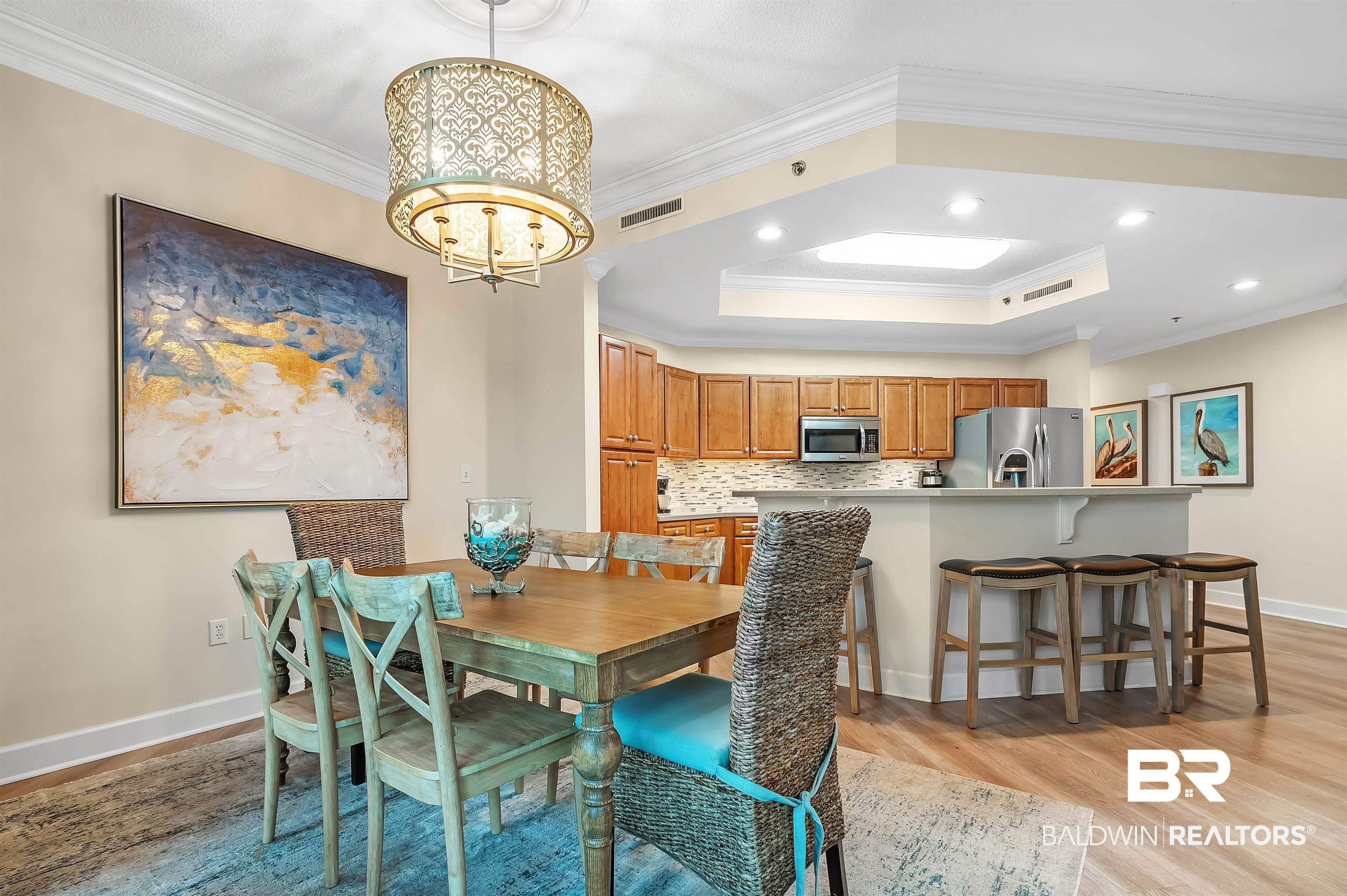 27582 Canal Road, Unit 2104 Orange Beach, AL 36561 - Photo 17 of 35 Dining area with crown molding, light hardwood / wood-style flooring, and a raised ceiling