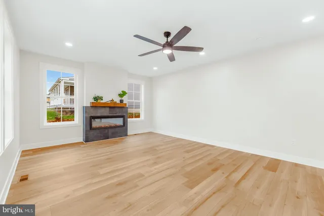 a view of empty room with wooden floor and windows
