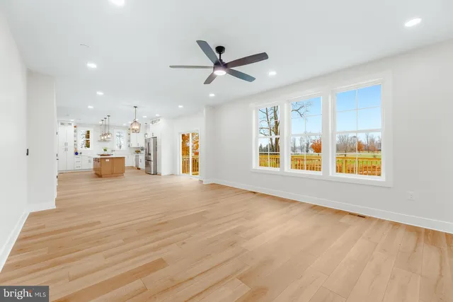 a view of empty room with wooden floor and window