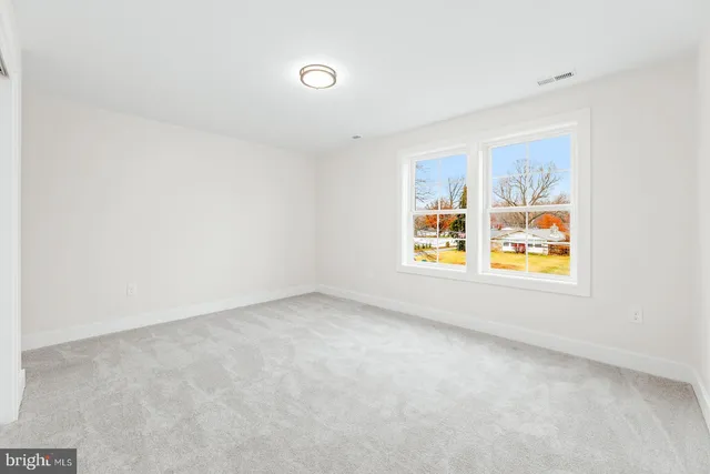 a view of staircase with lots of frames on wall and a window