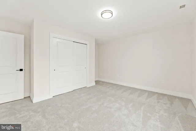 an empty room with a kitchen space and a window