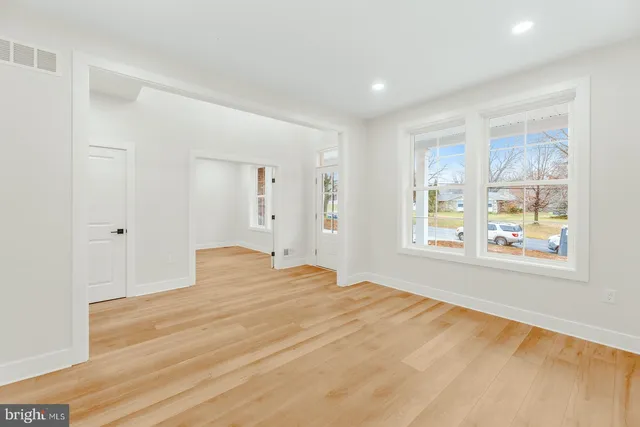 a view of a bedroom with wooden floor and windows