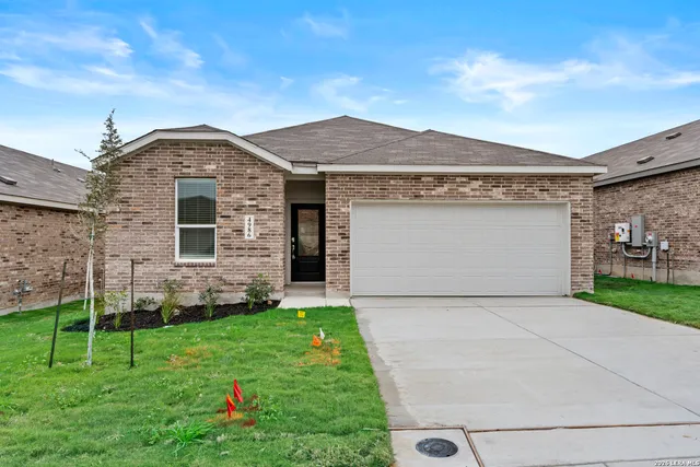 a front view of a house with a yard and a garage