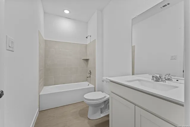 a bathroom with a sink a toilet and a large mirror