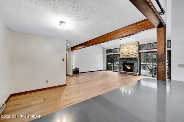 an empty room with fireplace and wooden floor