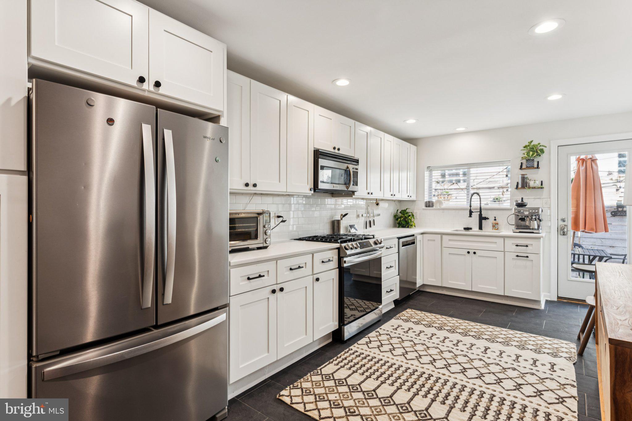 3005 Poplar Street Philadelphia, PA 19130 - Photo 16 of 53 a kitchen with white cabinets stainless steel appliances and a window
