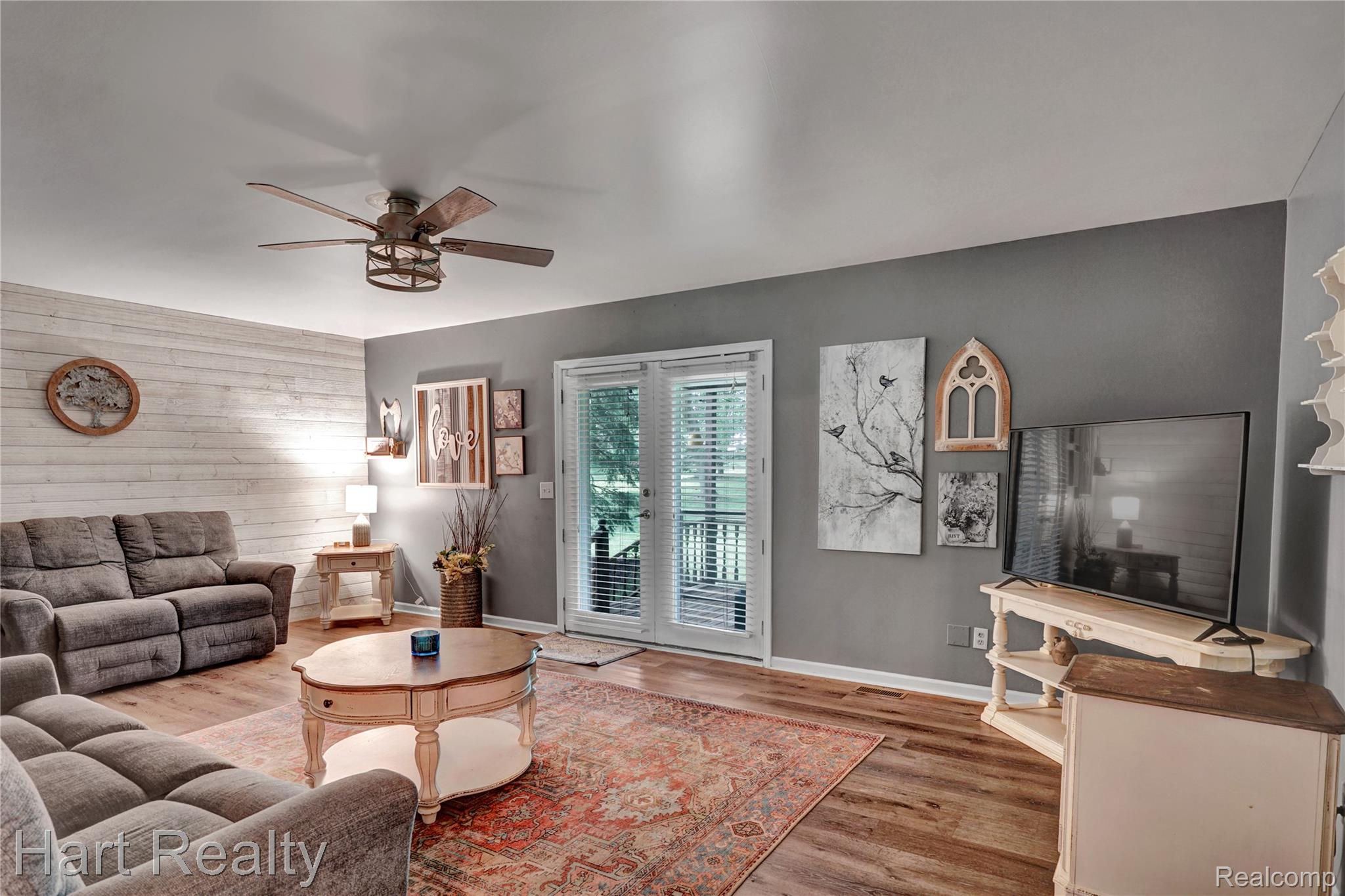 7167 Brown School Road North Branch, MI 48461 - Photo 13 of 51 Spacious living area featuring wood-finish flooring, a decorative accent wall, and a ceiling fan