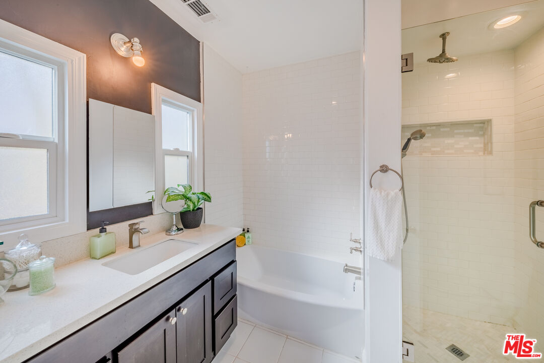 1251 South Muirfield Road Los Angeles, CA 90019 - Photo 11 of 24 a bathroom with a granite countertop sink and a mirror